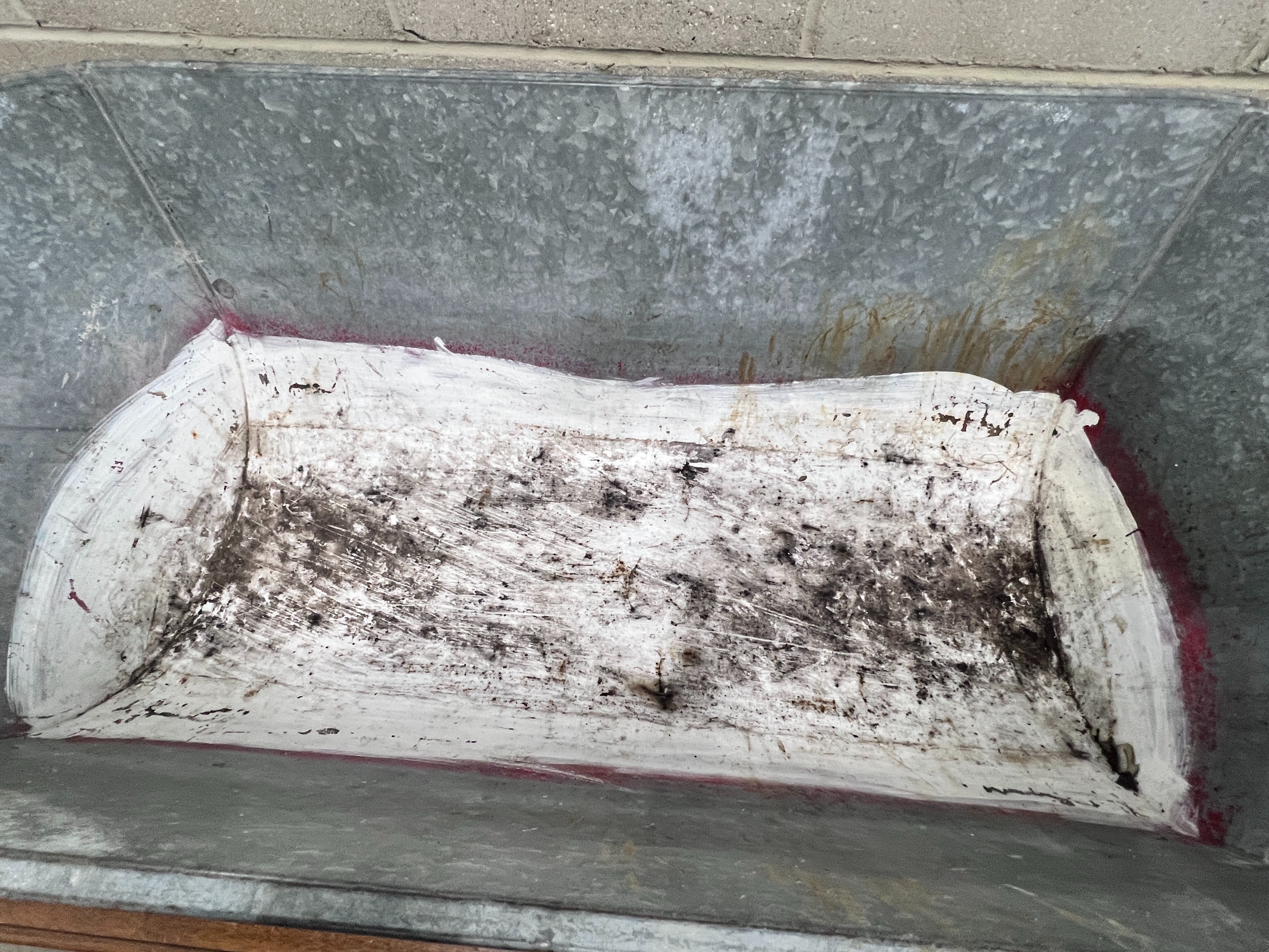 A vintage galvanised trough on wrought iron feet, length 146cm, depth 62cm, height 49cm